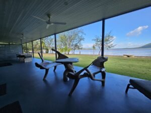 creative wood table and chairs on the patio next to the water